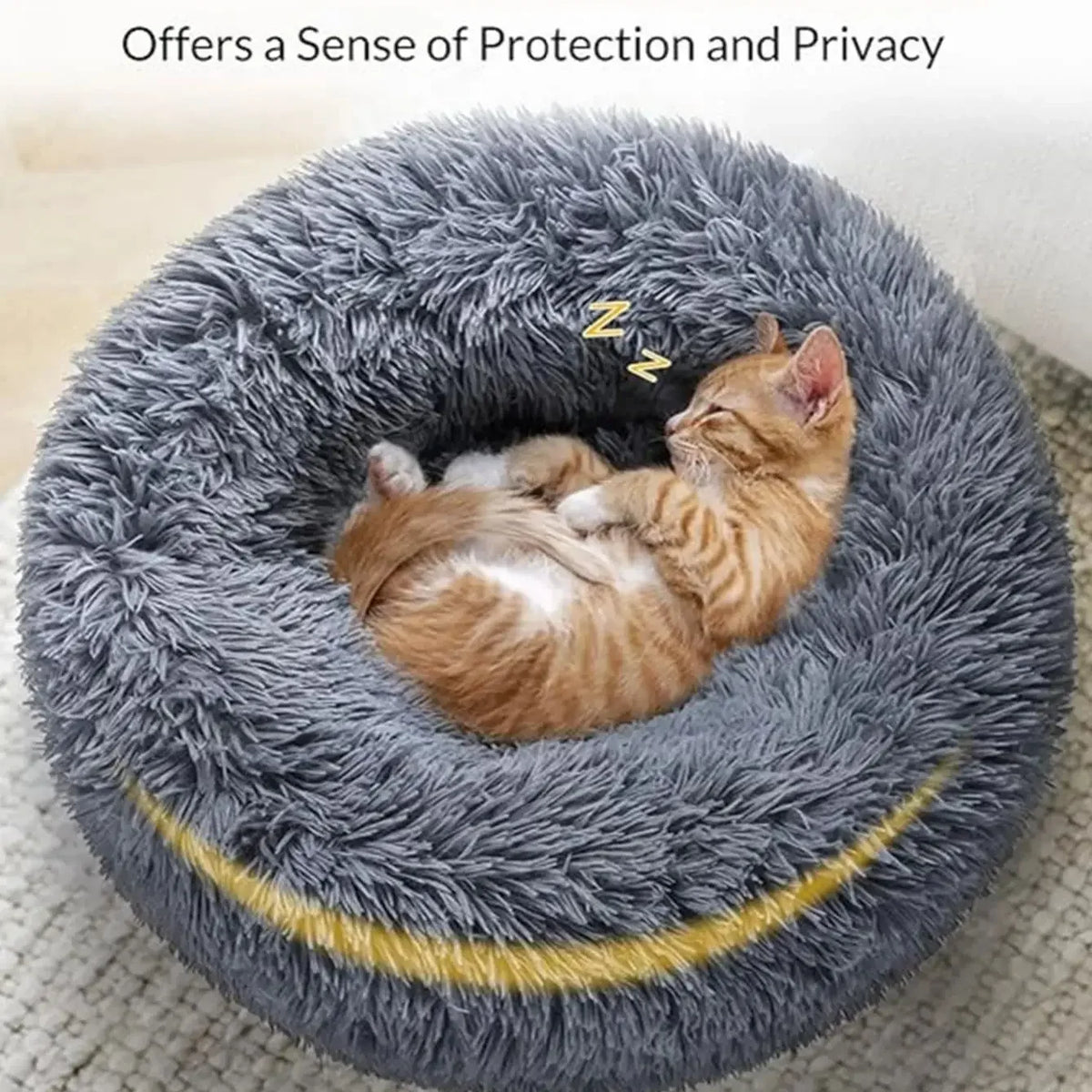 Chaton endormi dans le lit rond en peluche gris aux bords rehaussés
